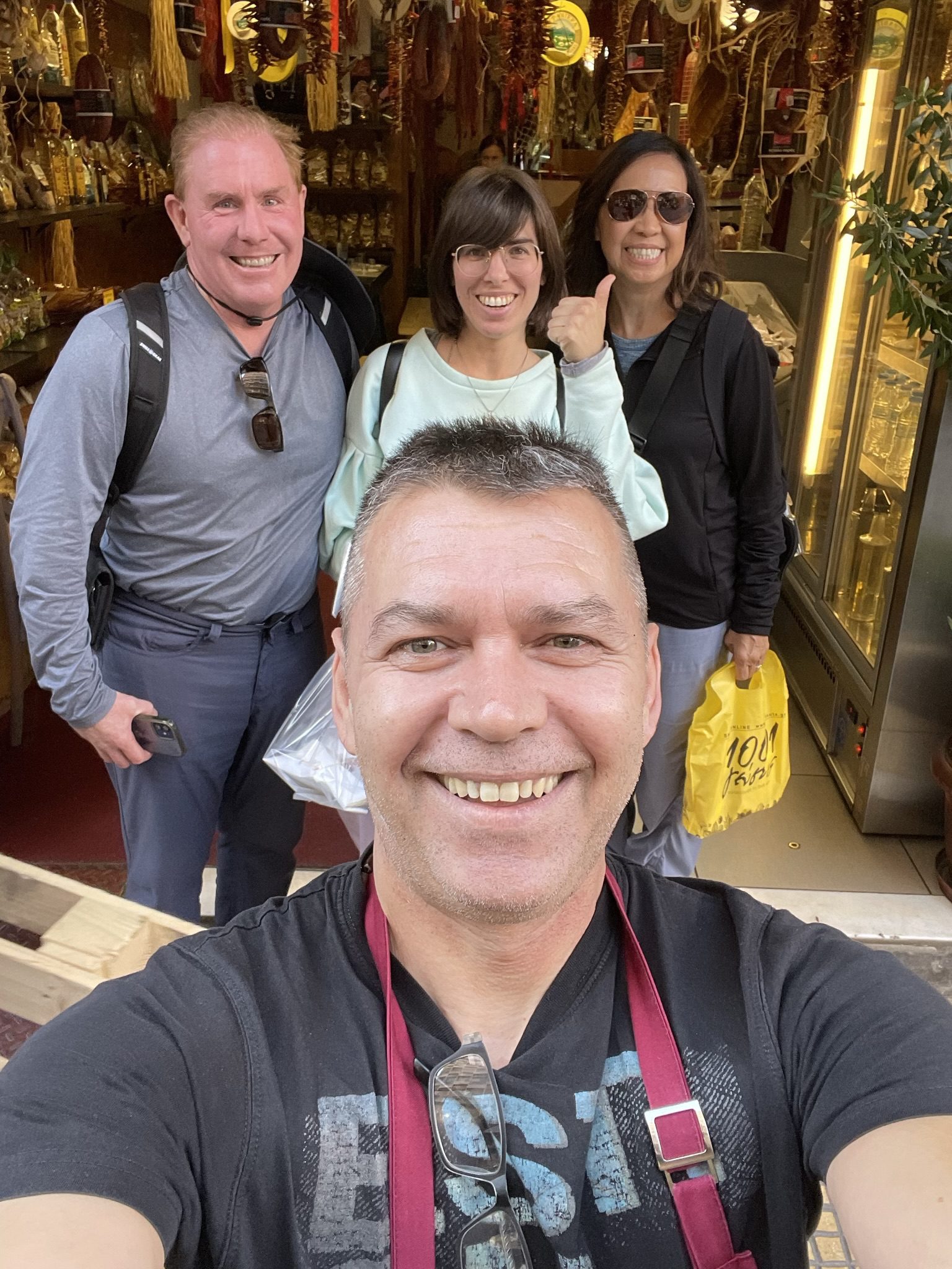 Group selfie in front of a shop.