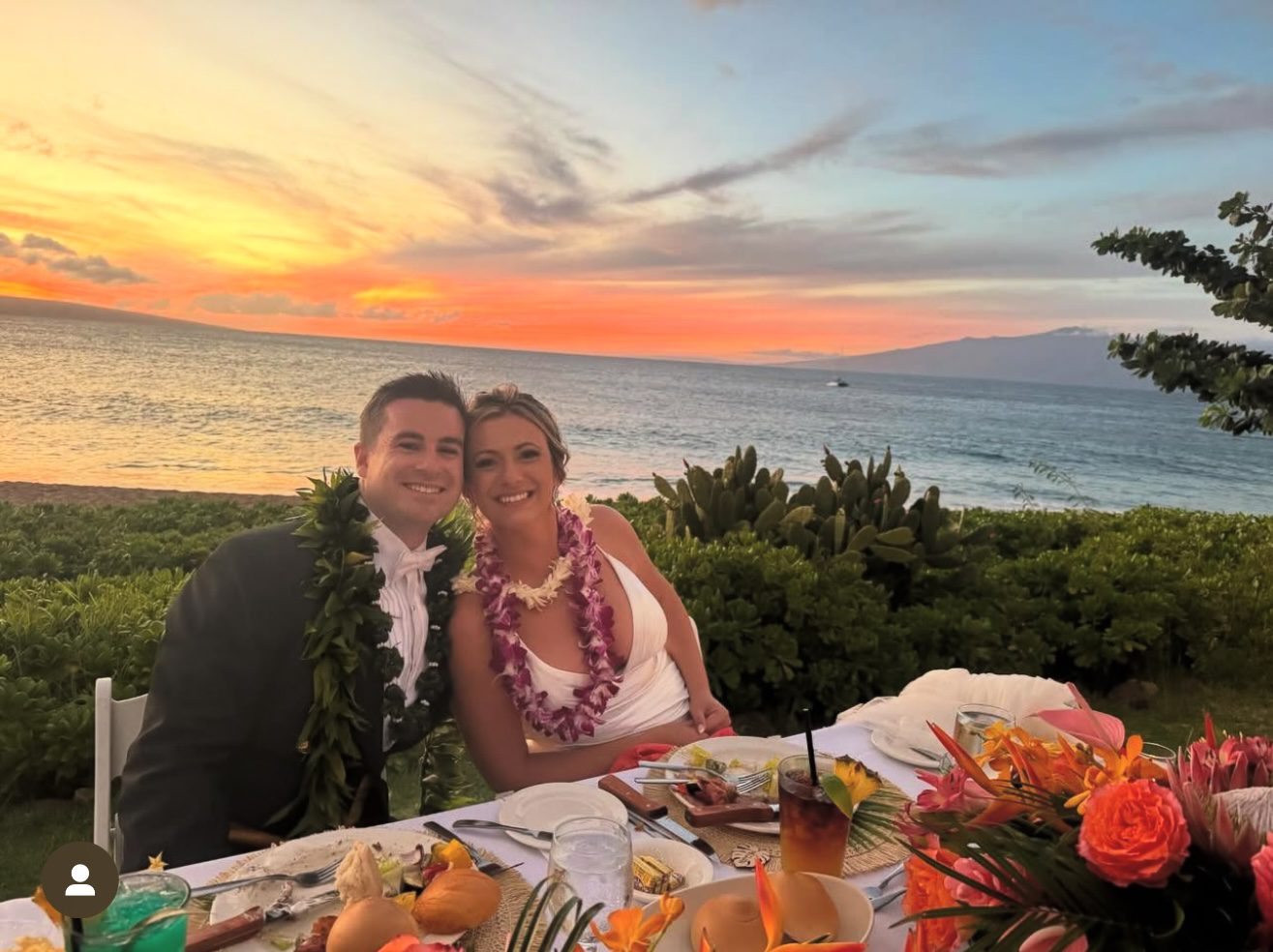Bride and groom at sunset beach reception.